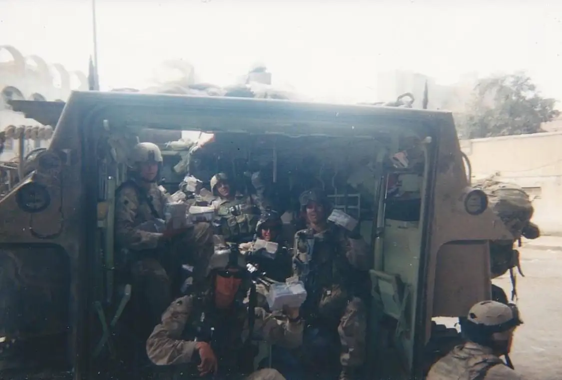 Soldiers sitting inside a military vehicle.