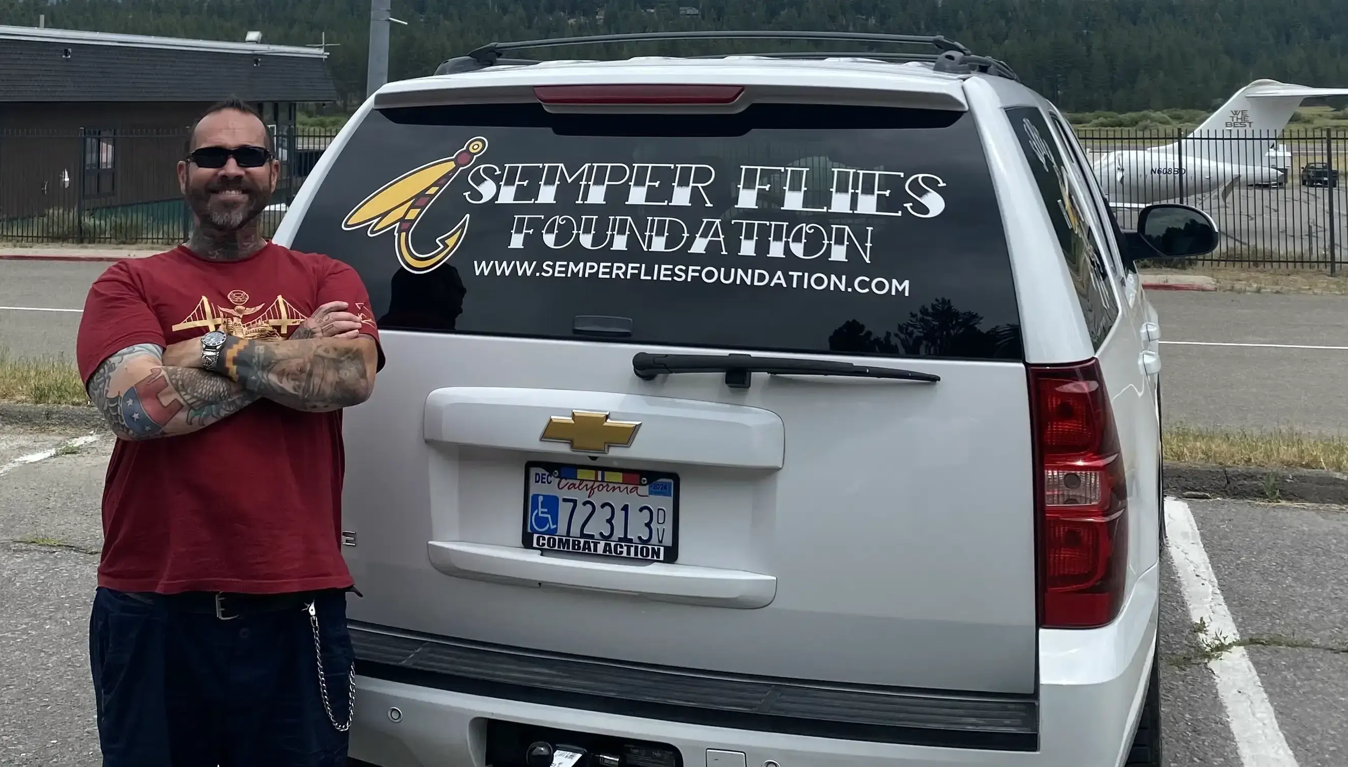 Man standing by SUV with foundation logo.