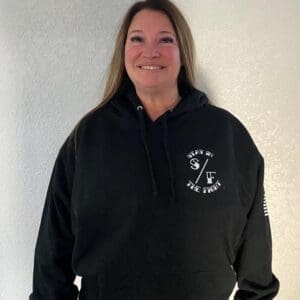 Smiling woman wearing a black hoodie with white graphics.