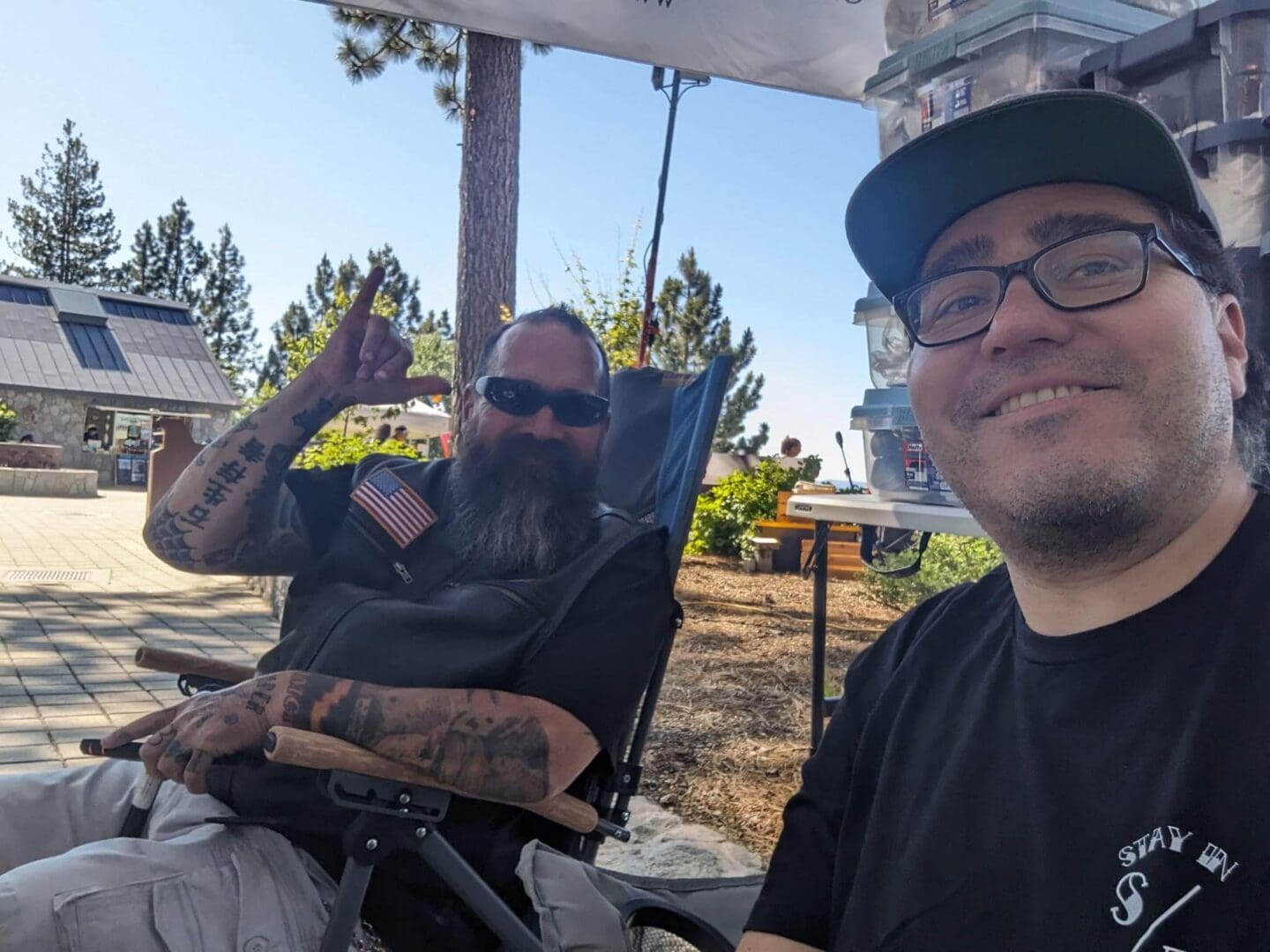 Two men smiling outdoors in sunny setting.