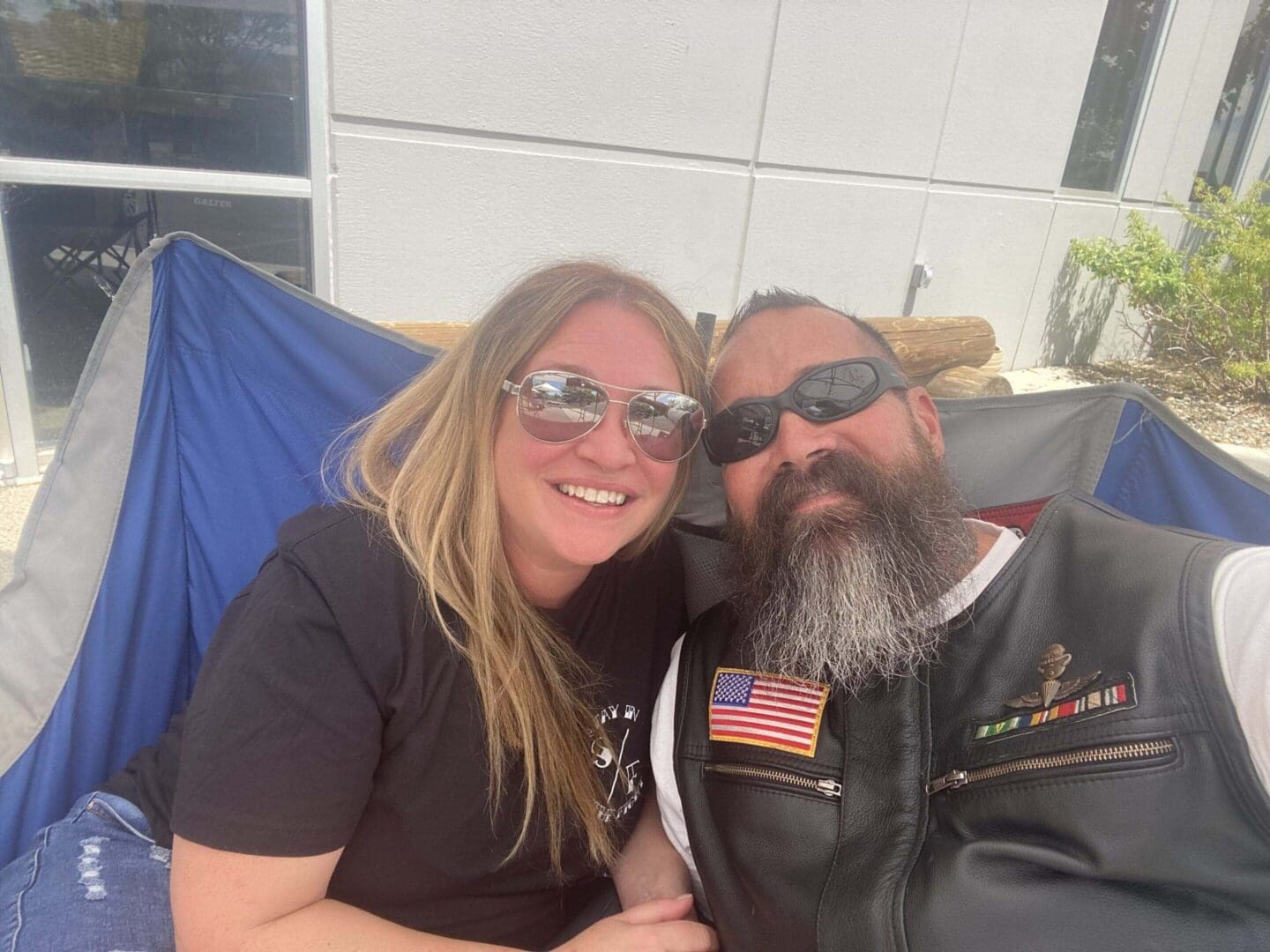 Woman and bearded man in sunglasses smiling