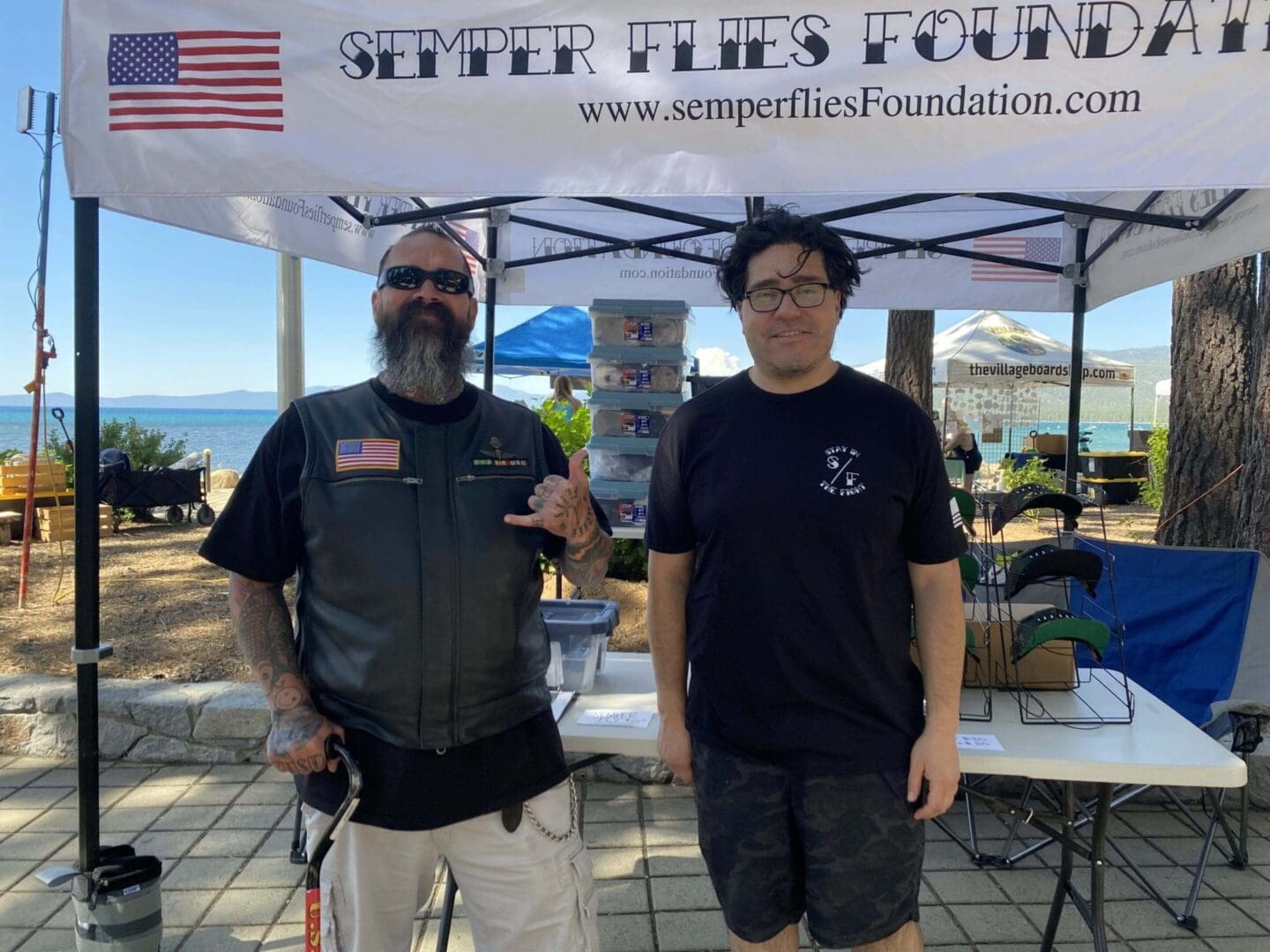 Two men under Semper Flies Foundation tent.