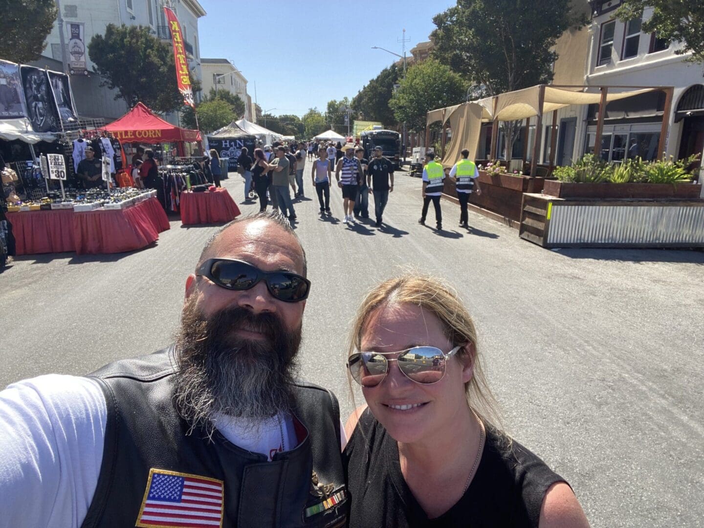 Smiling couple at outdoor street market event.