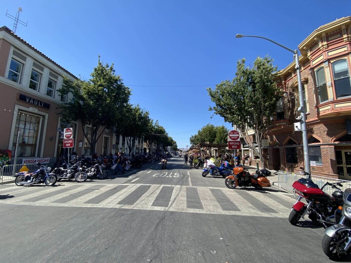 Street with parked motorcycles and surrounding buildings.