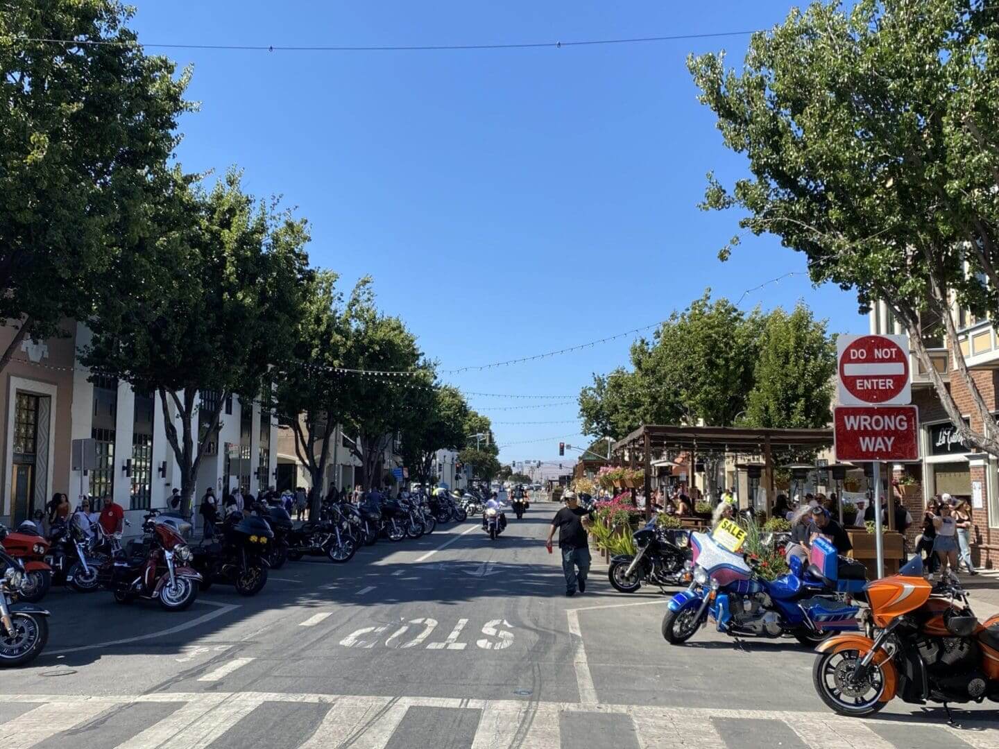 Street with parked motorcycles and "Do Not Enter" sign.