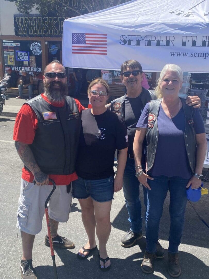 Group posing at outdoor event near booth.