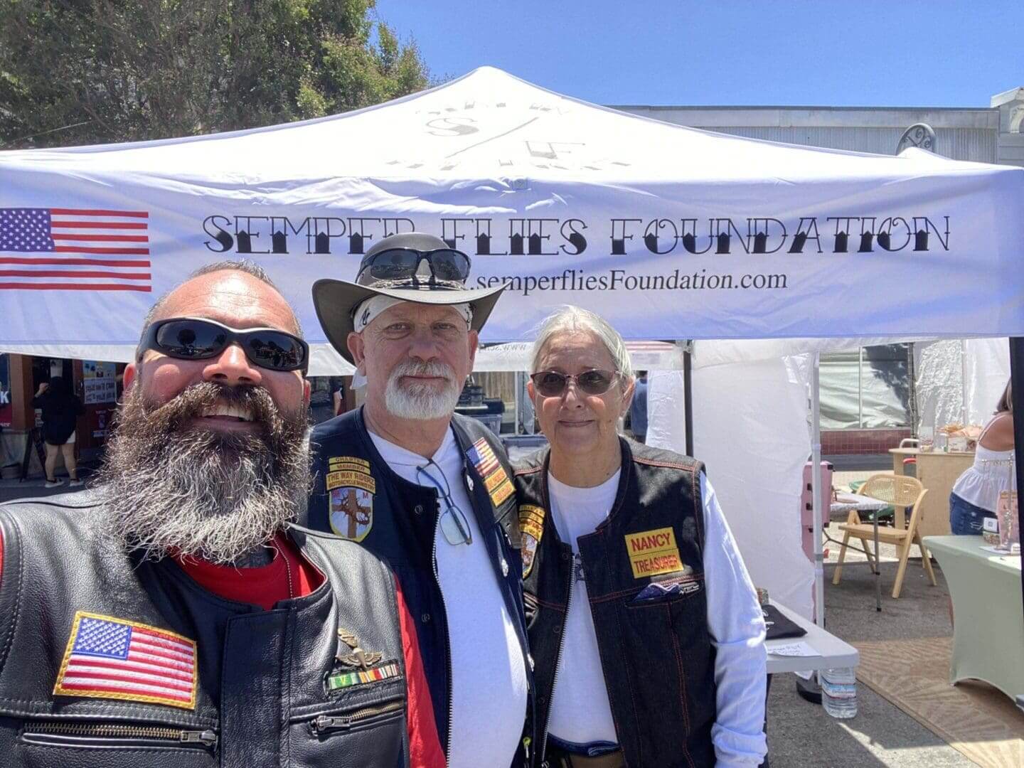 Three people at Semper Fi event booth.