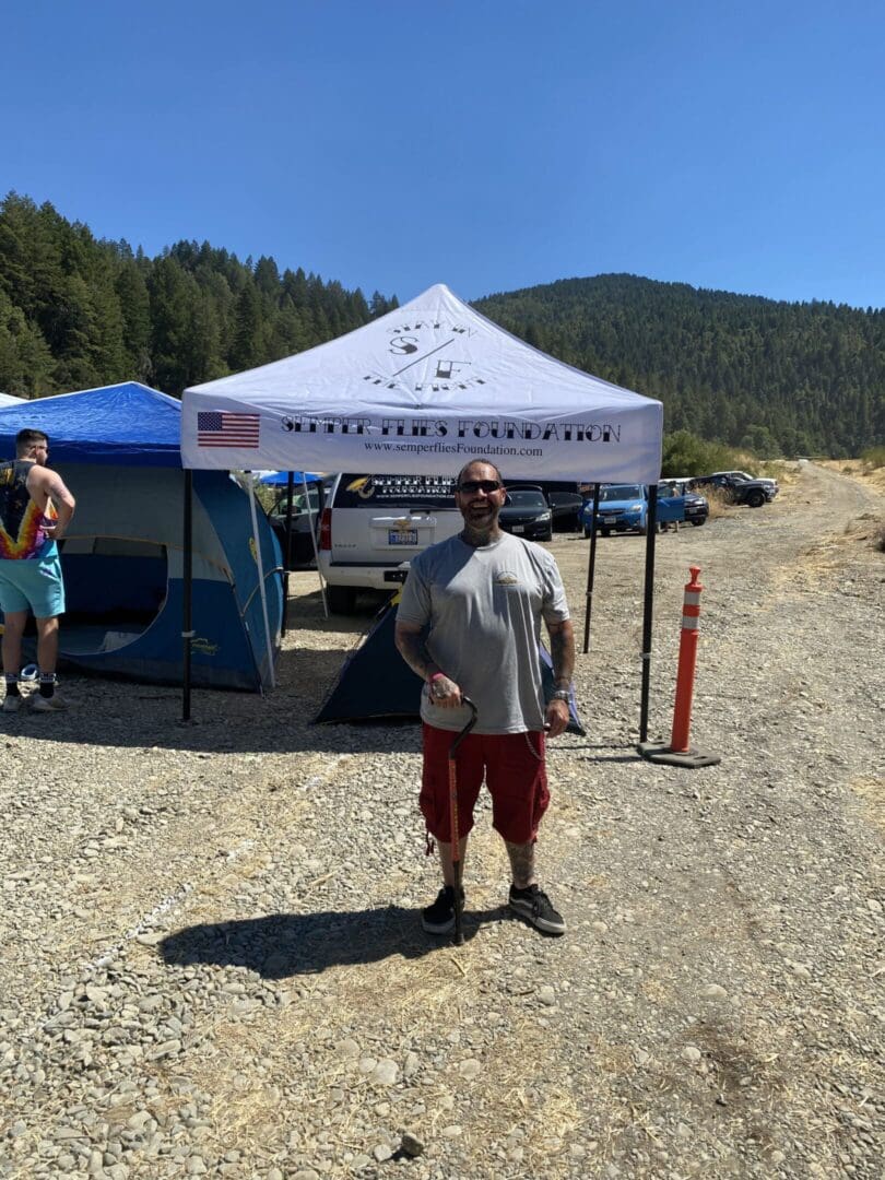 Man standing in front of outdoor tent.