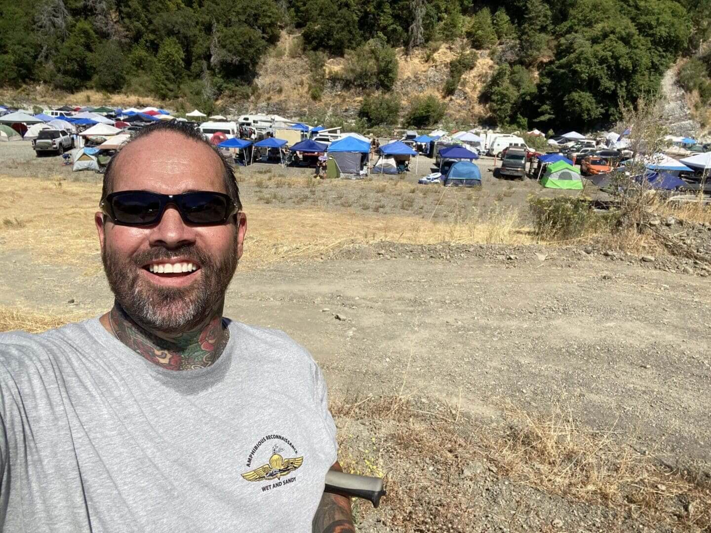 Smiling man at outdoor camping event.
