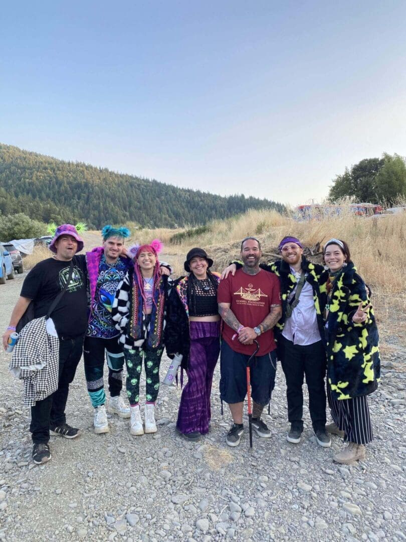 Group in colorful outfits outdoors on trail.