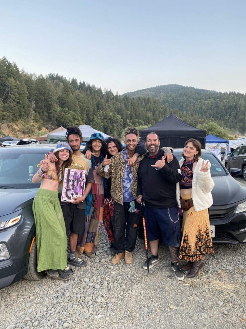 Smiling friends posing between parked cars