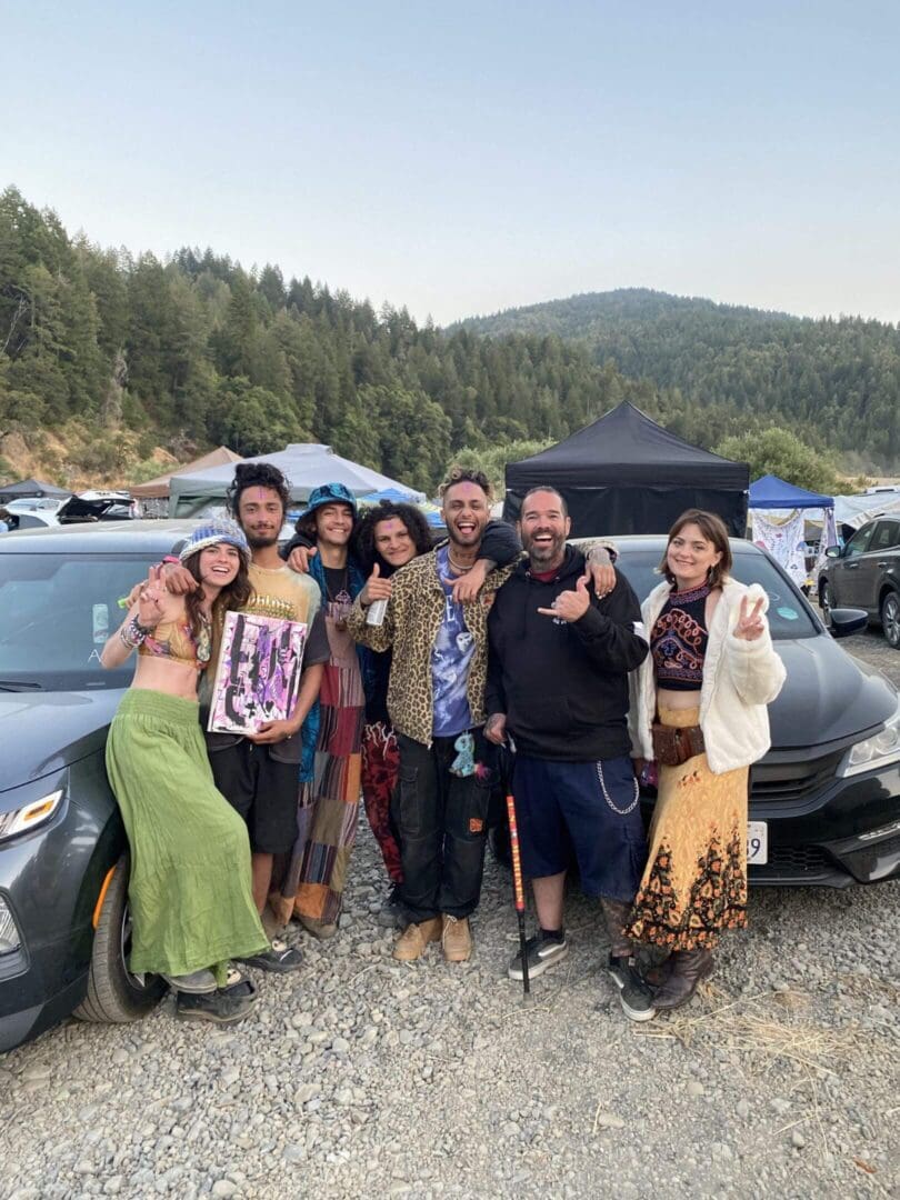 Smiling group leaning on car at campground